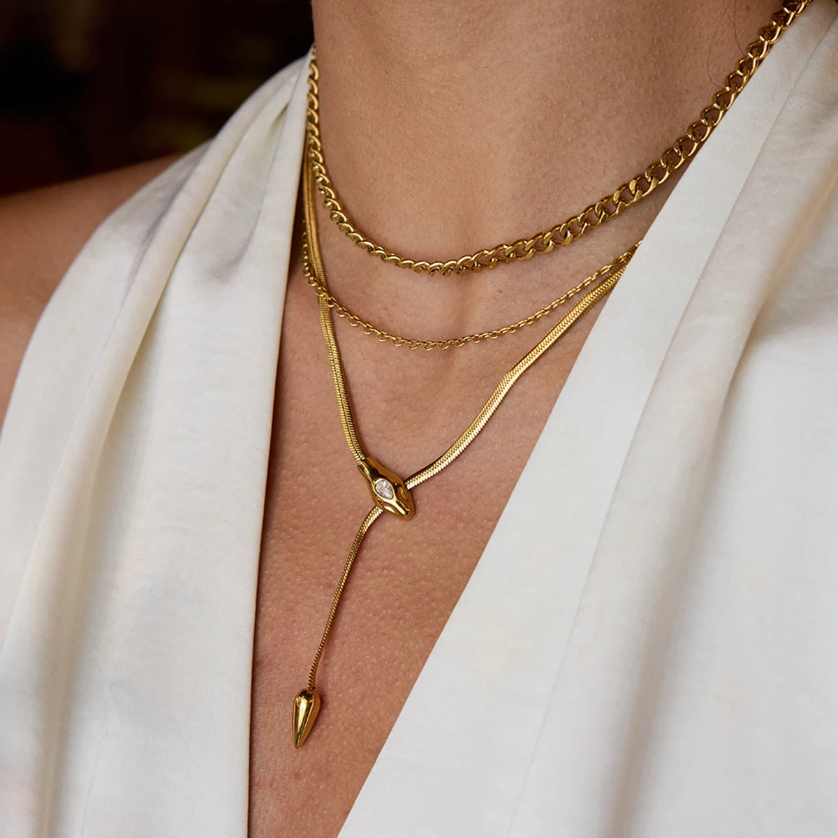 Gold necklaces on a person wearing a white garment
