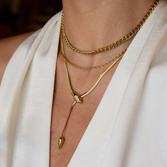 Gold necklaces on a person wearing a white garment